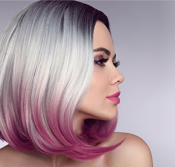 Carré court ombré argenté et rose vibrant sur une femme de profil avec maquillage élégant.